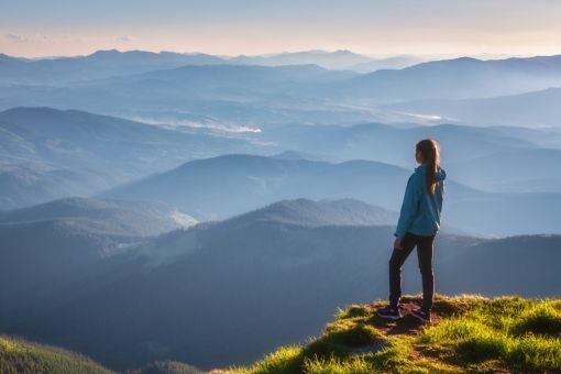 A woman is watching the forest from a mountain